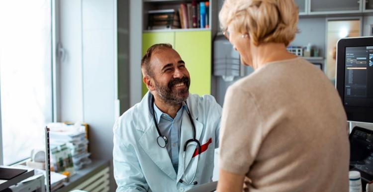 GP talking to a lady in his surgery