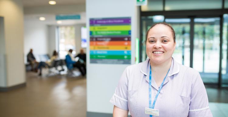 A nurse smiling at the camera in a hospital 