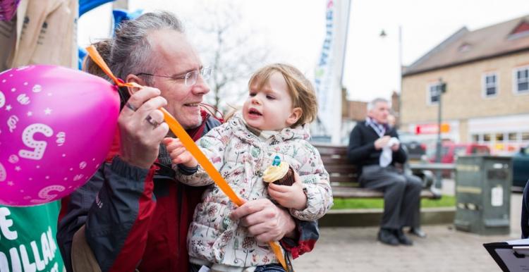 Elderly man holding a young child at an event