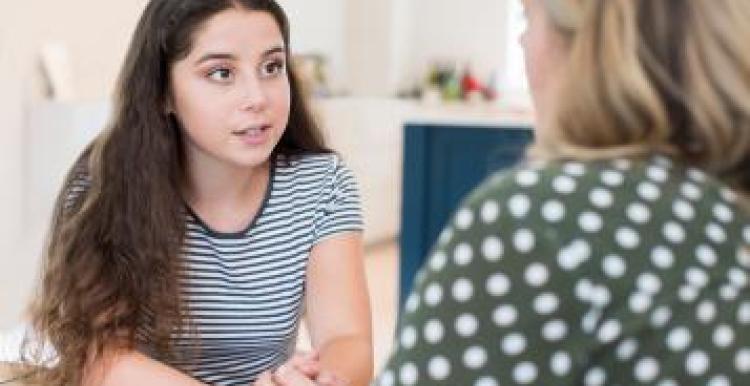 A young woman talking to another woman