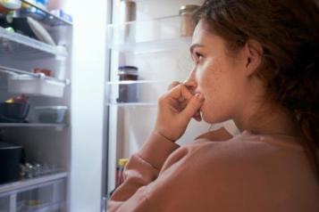 A young woman looking into her fridge