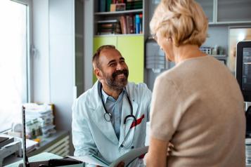 GP talking to a lady in his surgery