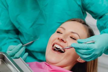 A lady having her teeth checked by a dentist